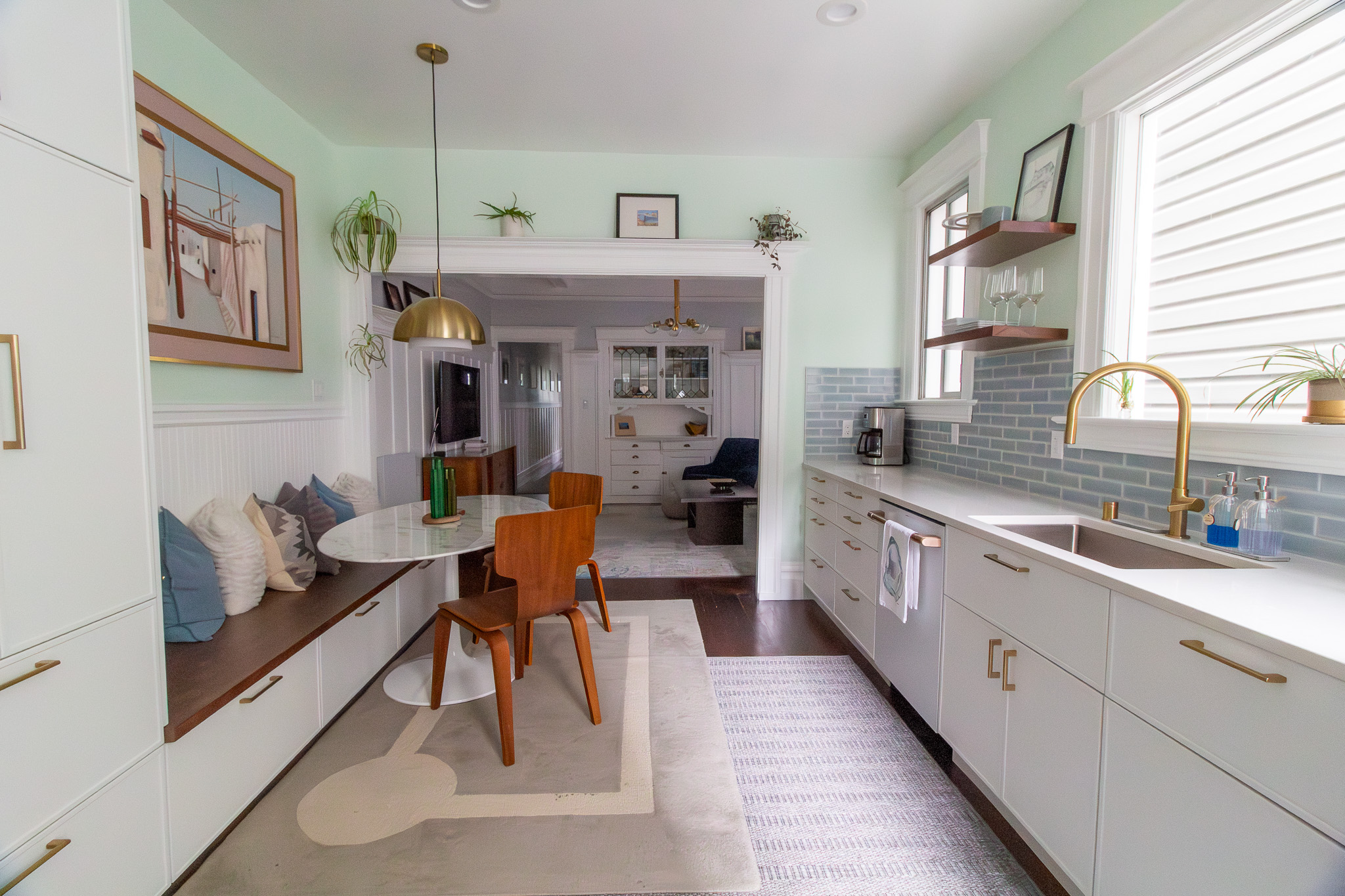 kitchen with white cabinets blue tile and walnut floating shelves 