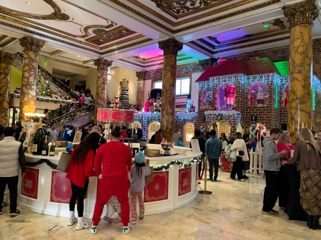 Lobby of the Fairmont hotel in San Francisco at Christmas with a champagne bar and giant gingerbread house and a family in red pajamas