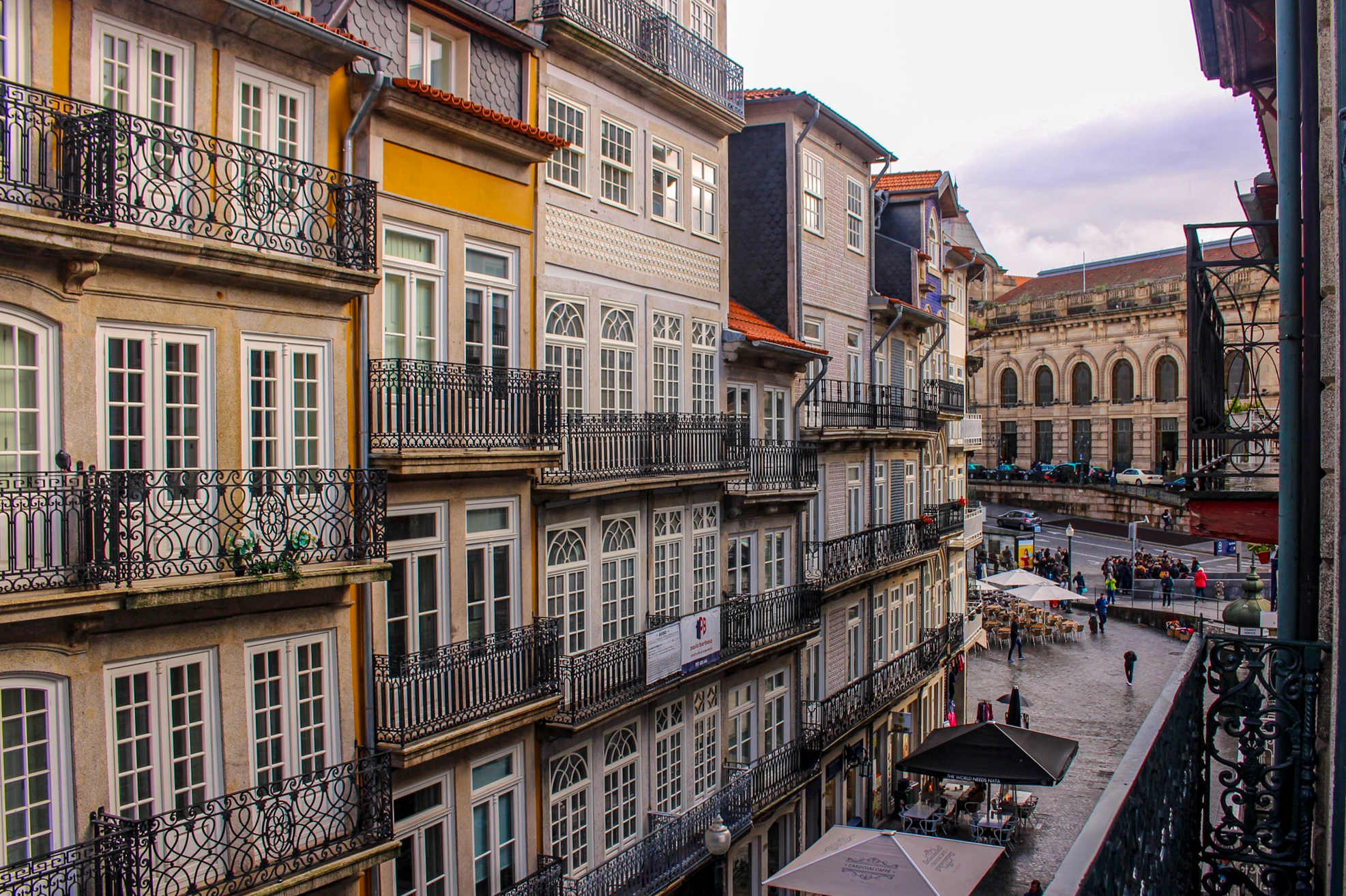 Looking towards the train station at the buildings with decorative metal balconies in porto portugal