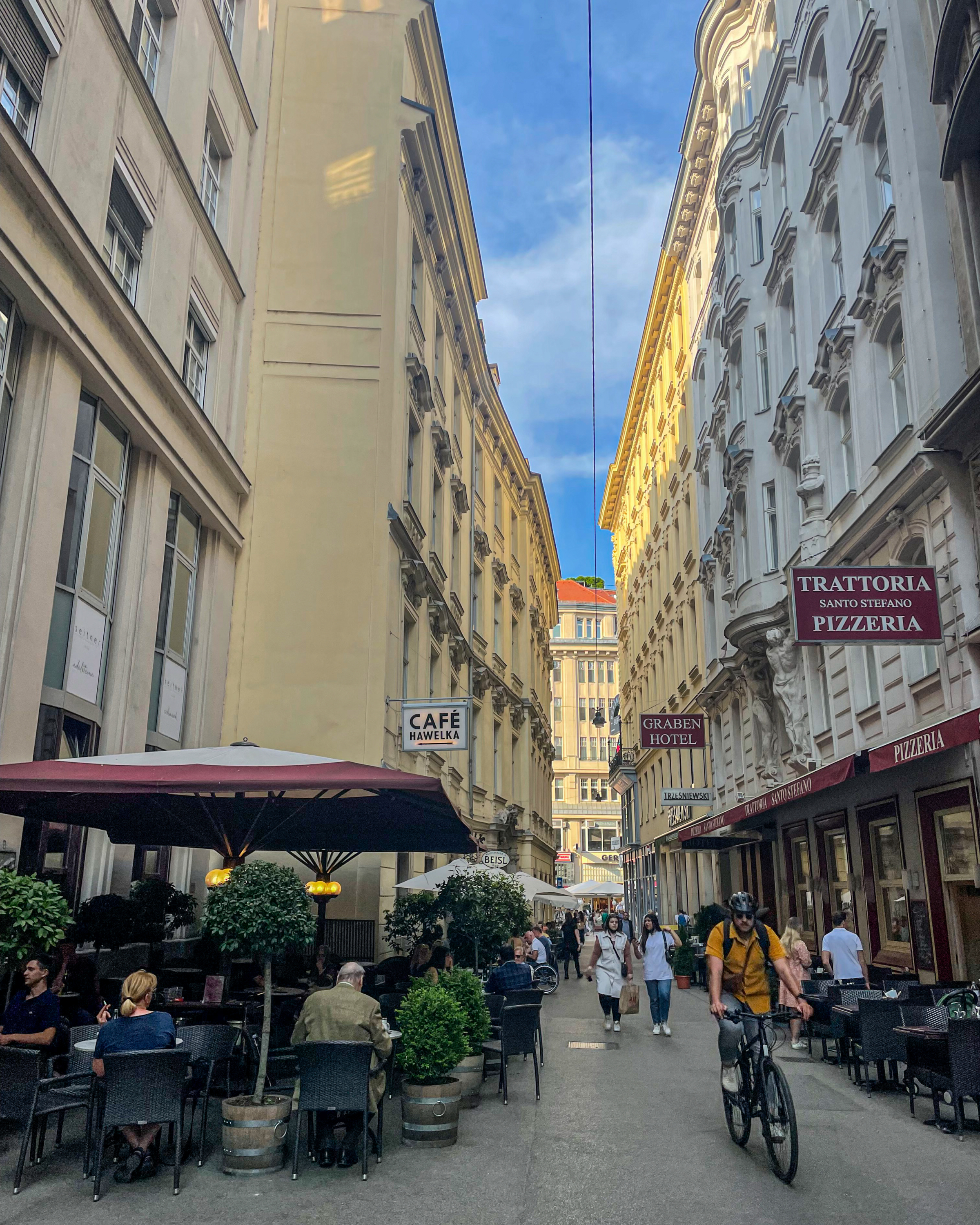 pedestrian street cafe in vienna austria with a cyclist riding past