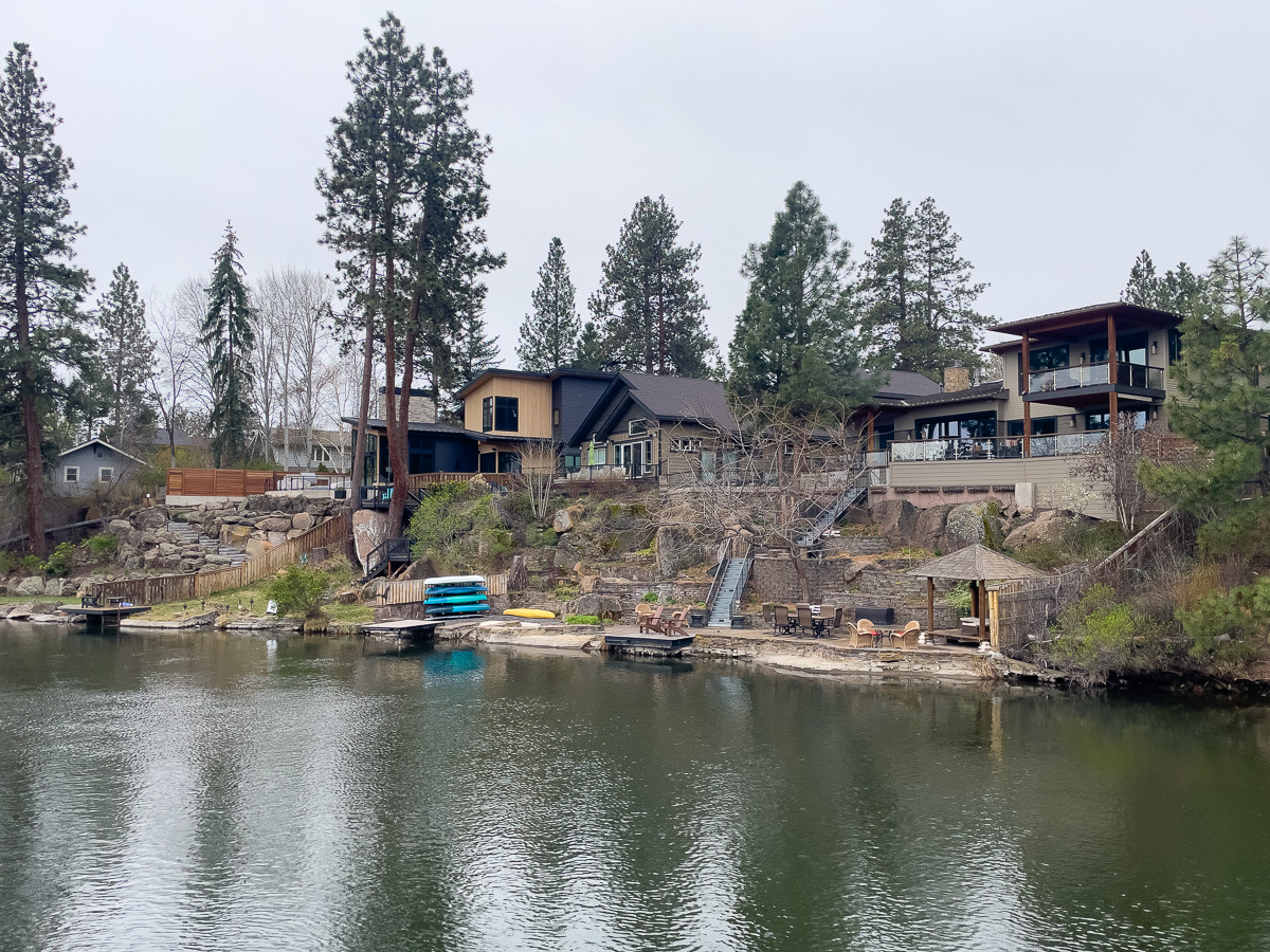 View of houses along the Deschutes River in Bend from the Gilchrist pedestrian bridge, architecture in Bend, Oregon
