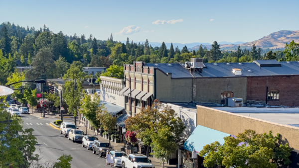 Overlooking Main Street in Ashland Oregon with pine trees in the background and historic brick buildings, charming town in Southern Oregon