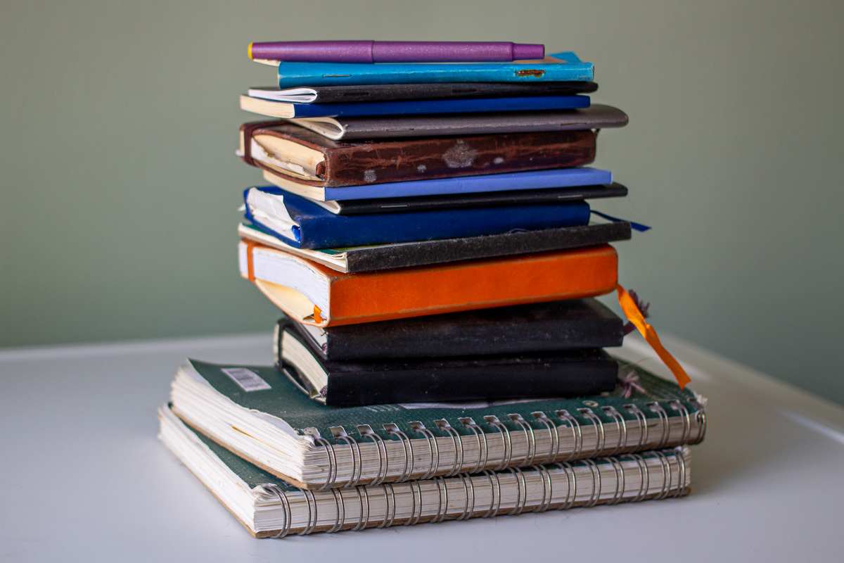 Stack of travel journals and sketchbooks